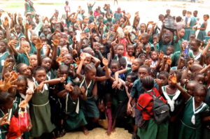 Excited primary school students wave to the camera
